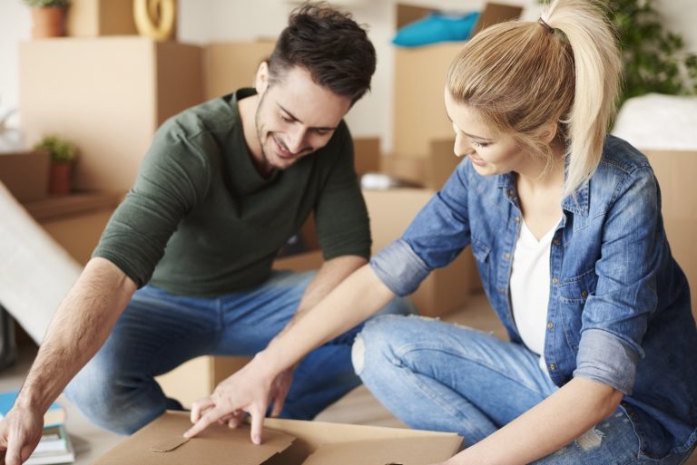 Couple packing their belongings into moving boxes