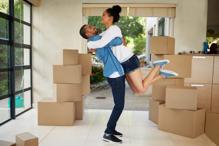 Family celebrating in their new home among moving boxes