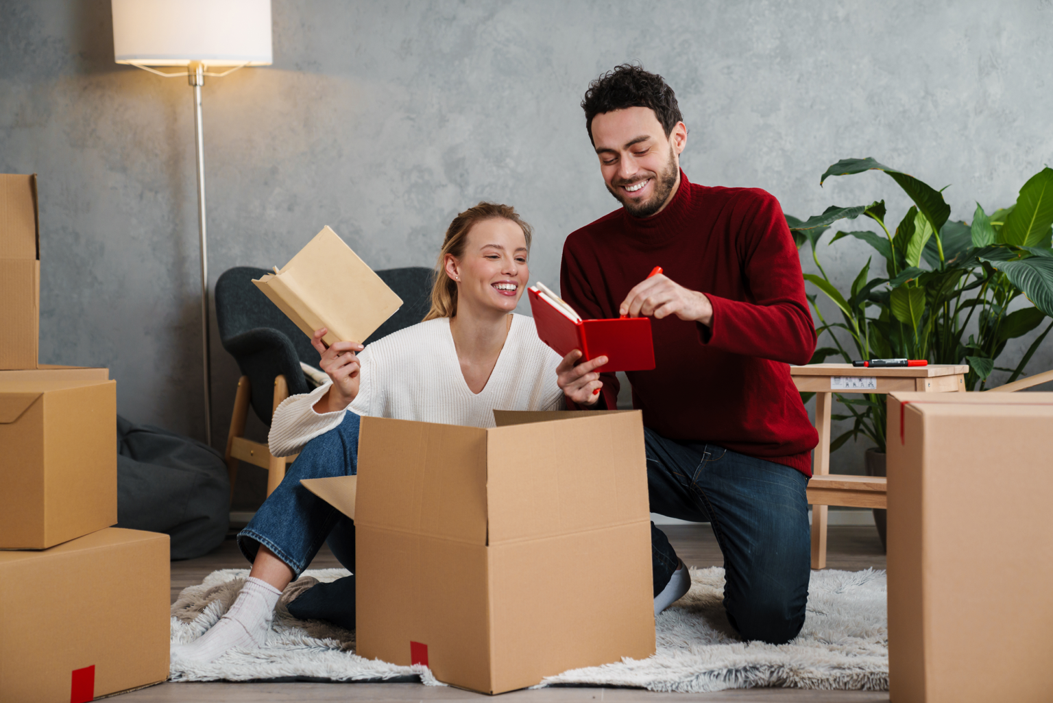 Couple unpacking moving boxes in their new home